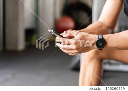 Fitness Technology. Athlete checking fitness app on smartphone during gym break. Fitness Technology. Athlete checking fitness app on smartphone during gym break. 126260329