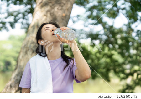 Wellness and Hydration. Woman drinking water to stay refreshed after outdoor fitness. 126260345