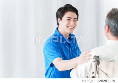 男性介護士と車椅子に乗った高齢者男性 126261119