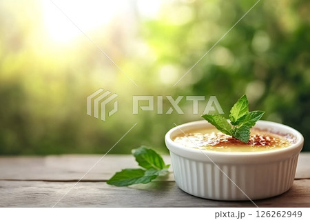 Delicious creme brulee decorated with mint leaves on wooden table outdoors Delicious creme brulee decorated with mint leaves on wooden table outdoors 126262949