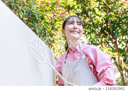 布団叩きをする女性 126262962