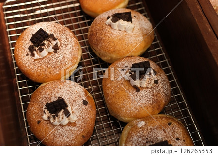 Soft and fluffy Berliner. German Doughnut with swiss chocolate cream inside. dark chocolate pieces decorate 126265353