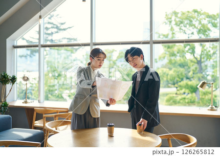 書類の内容を確認する二人 126265812