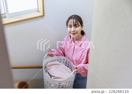 洗濯かごを持つ若い女性 洗濯かごを持つ若い女性 126266110