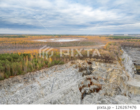 Stone quarry in the forest. Flying over the autumn mixed forest during sunset. The surroundings of Yekaterinburg. Ural, Russia, Aerial View Stone quarry in the forest. Flying over the autumn mixed forest during sunset. The surroundings of Yekaterinburg. Ural, Russia, Aerial View 126267476