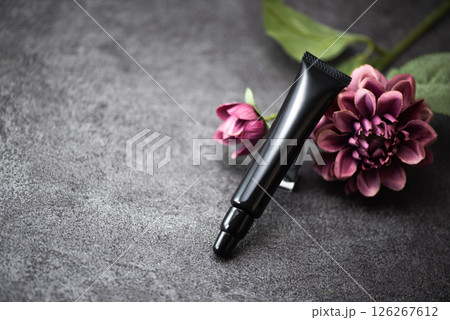 化粧品の黒いチューブ容器とピンク色の花 126267612