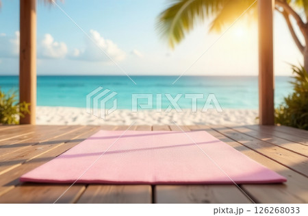 Pink yoga mat lying on wooden terrace, clear seascape blurred in background 126268033