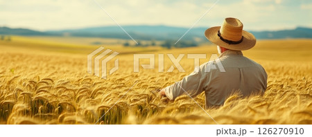 Farmer Inspecting Lush Golden Wheat Field in Scenic Rural Landscape 126270910