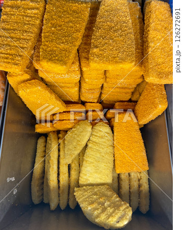 Frozen semi-finished chicken and fish products lying in the freezer at the store, vertical picture 126272691