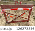 Wooden fence with red tape, sign that the passage is closed, construction work is underway 126272836