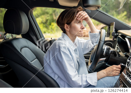 Stressed middle aged woman driving car having problems on road looking ahead. 126274414
