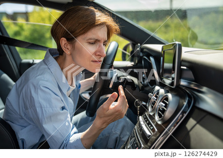 Bad smell from ac inside car. Woman driver feels an unpleasant odor after turn on air conditioning 126274429