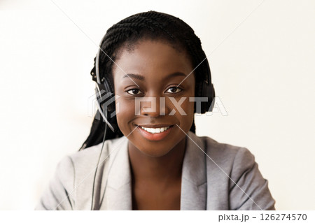 Customer service operator. Portrait of smiling black female call center representative in headset, closeup 126274570