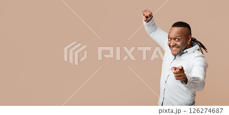 We need you. Positive african american mature man pointing at camera, orange studio background 126274687