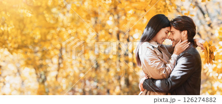 Love, affectionate, feelings concept. Loving man and woman cuddling while walking by golden forest, copy space Love, affectionate, feelings concept. Loving man and woman cuddling while walking by golden forest, copy space 126274882