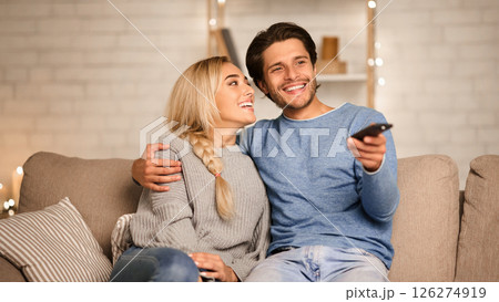 Cute couple in love watching TV, enjoying cozy atmosphere at home, free space 126274919