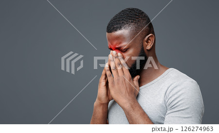 Exhausted afro man rubbing nose bridge, suffering from antritis, white background, copy space 126274963