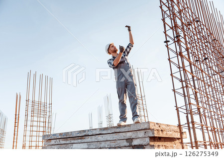 On construction site. Man in grey uniform is working On construction site. Man in grey uniform is working 126275349