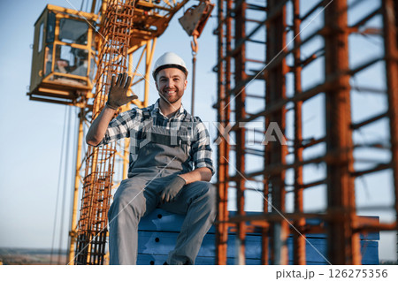 Sitting and smiling. Man is working on the construction site at daytime 126275356