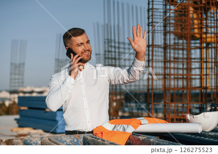 Businessman in formal clothes is on the construction site at daytime 126275523