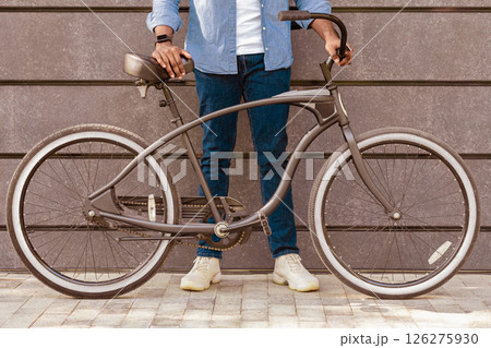 Unrecognizable Afro Man Holding Bicycle With Stylish Design, Standing Over Grey Urban Wall, Cropped Image, Closeup 126275930