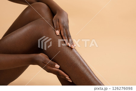 Cropped of african american woman touching her hairy legs, hair removing cosmetics, epilation, laser hair removal, waxing concept, beige studio background, panorama with copy space Cropped of african american woman touching her hairy legs, hair removing cosmetics, epilation, laser hair removal, waxing concept, beige studio background, panorama with copy space 126276098