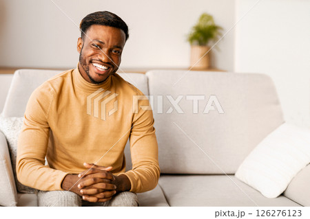 Successful Entrepreneur. Confident Black Man Smiling At Camera Sitting On Couch Indoor. Successful Entrepreneur. Confident Black Man Smiling At Camera Sitting On Couch Indoor. 126276123