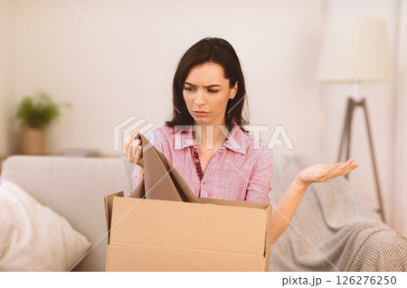 Something Wrong. Confused girl looking at clothes in box, shipping mistake, copyspace 126276250