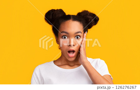 Shocking News. Surprised young black woman staring at camera with opened mouth, palm on cheek. Panorama, free space Shocking News. Surprised young black woman staring at camera with opened mouth, palm on cheek. Panorama, free space 126276267