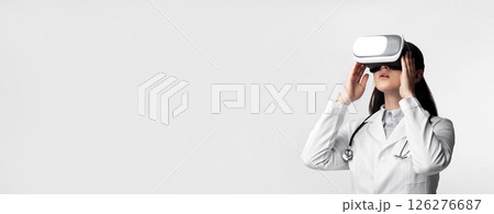 High-Tech Medicine. Female Doctor Using Virtual Reality Headset For Medical Diagnosis Over White Studio Background. Free Space 126276687
