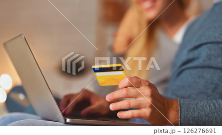Unrecognizable Spouses Shopping Online Holding Laptop And Credit Card Sitting On Sofa Indoor. Selective Focus, Cropped Unrecognizable Spouses Shopping Online Holding Laptop And Credit Card Sitting On Sofa Indoor. Selective Focus, Cropped 126276691
