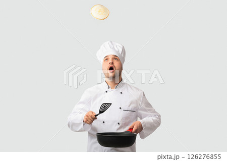 Cooking Food. Surprised Chef Man Holding Pan And Spatula Looking Up Standing Over White Background. Studio Shot 126276855