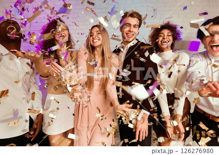 Joyful Millennial People Partying Dancing Under Falling Shiny Confetti Having Fun On Corporate New Year Party Indoor. 126276980