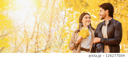 Romantic smiling couple walking through autumn park, talking and enjoying date, panorama with free space Romantic smiling couple walking through autumn park, talking and enjoying date, panorama with free space 126277084