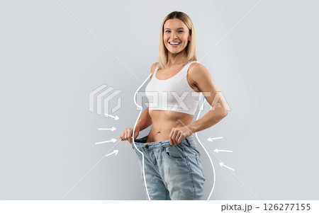 Cheery attractive slender middle aged blonde woman wearing huge jeans, showing results of diet, white body shape lines around happy slim lady, collage for slimming concept, copy space 126277155
