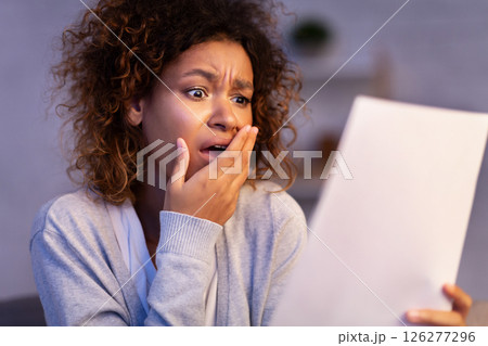 Shocked woman reading unexpected letter from husband, girl covering mouth with hand Shocked woman reading unexpected letter from husband, girl covering mouth with hand 126277296