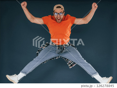 Jumping, feeling good, excited. Handsome man is in the studio against blue background 126278845