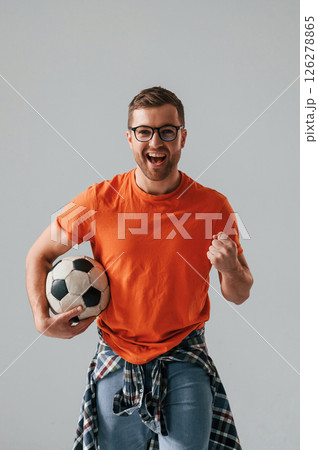 Active football fan is with soccer ball. Handsome man is in the studio against white background Active football fan is with soccer ball. Handsome man is in the studio against white background 126278865