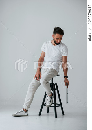 On the chair with laptop. Handsome man is in the studio against white background 126279032