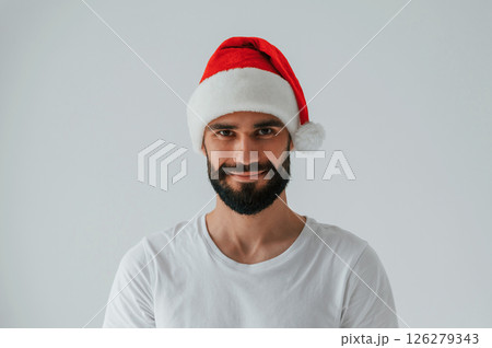 In santa hat. Handsome man is in the studio against white background 126279343