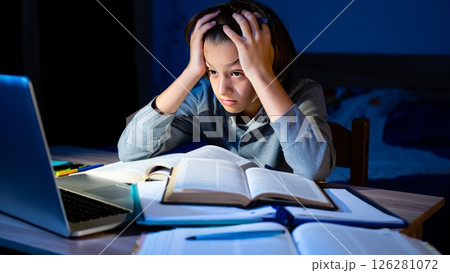Teen Overwhelmed by Homework at Night Desk Setup 126281072