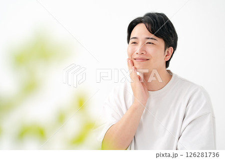 笑顔で頬を触る男性 126281736