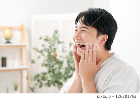 笑顔で頬を触る男性 126281762