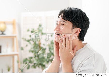 笑顔で頬を触る男性 126281763
