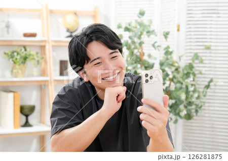 スマホを見て笑う男性 126281875