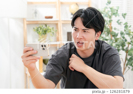 スマホを見て笑う男性 126281879