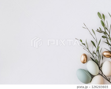 A simple and elegant Easter-themed arrangement featuring white and gold eggs nestled among green branches. The minimalist design creates a peaceful and refined holiday atmosphere. 126283603