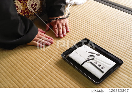 法要でお布施を渡すシーン 法要でお布施を渡すシーン 126283867