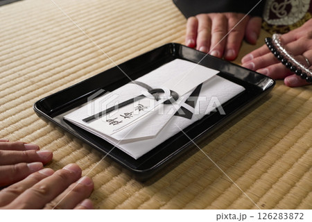 法要でお坊さんにお布施を渡すシーン 126283872