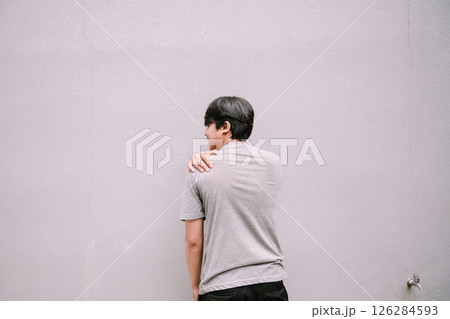 back view of asian man standing on gray wall 126284593